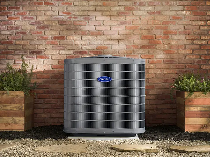 Representative Carrier outdoor air conditioning equipment against a brick wall